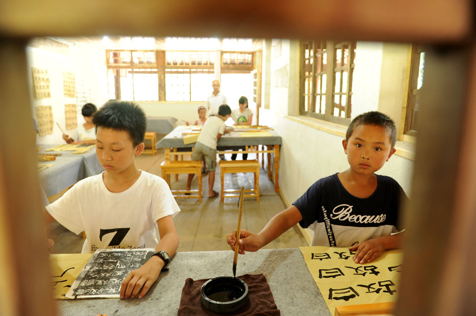 8月17日，孩子們在國學班課堂上練習書法。